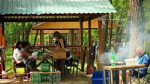Беседка с обеденным столом и мангалом на территории базы